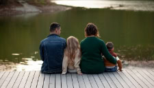 parents sitting on dock with kids